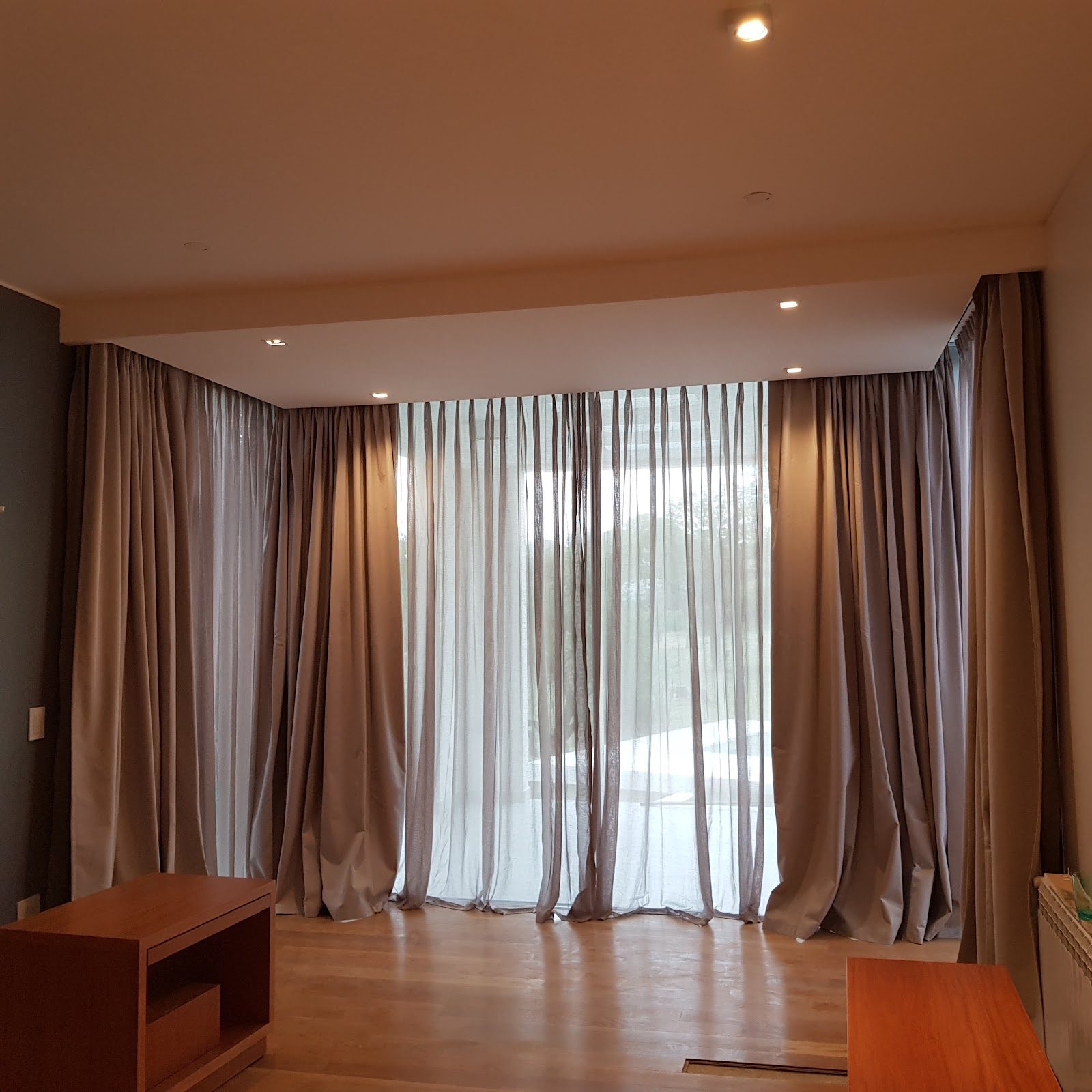 Cortinas tradicionales de voile y blackout en un living